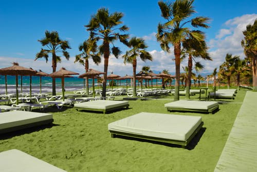 Sun loungers on a golden beach in Marbella, car hire by easyCar